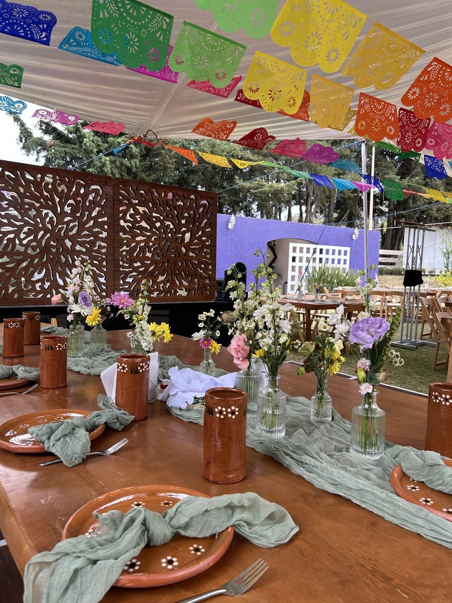 Mesa decorada con papel picado y flores para una celebración