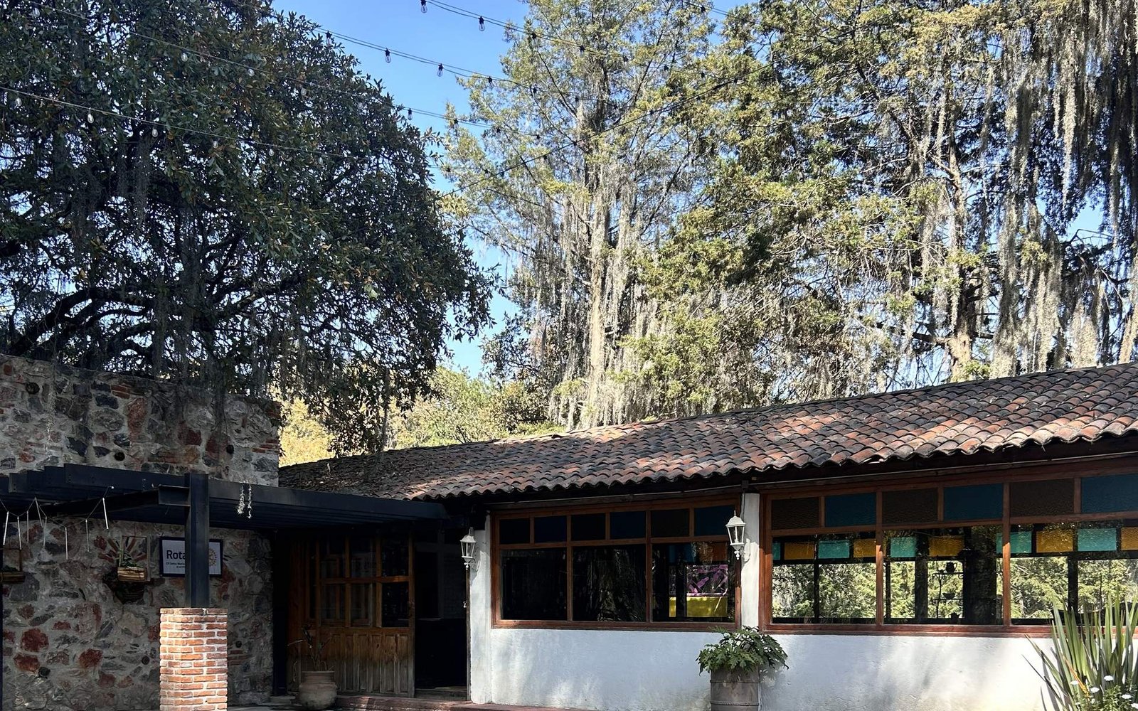Jardín campestre de Cabañas El Encanto, con techo de teja, pinos y luces de fiesta, en Tlahuapan, Puebla